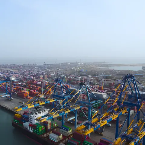 Aerial view of quay cranes and stacked containers along the Mundra port waterfront